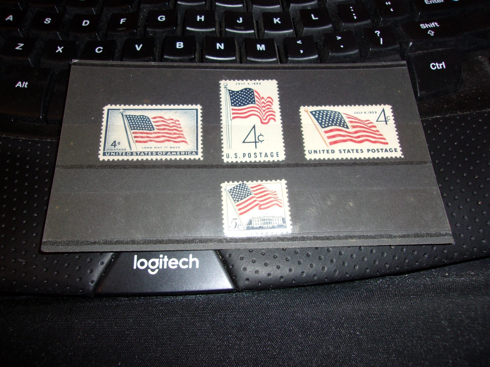 Four American Flag Stamps, 3 are 4 cent and 1 is 5 cent stamp In display folder