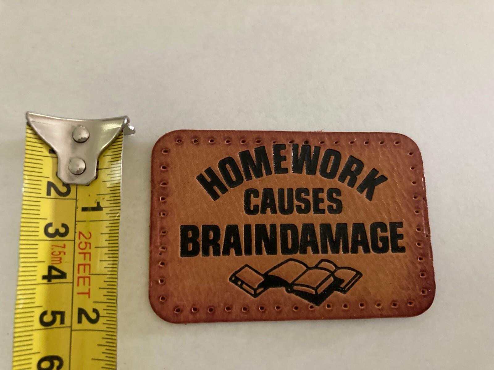 “HOMEWORK CAUSES BRAINDAMAGE” LEATHER PATCH – FUNNY LEATHER PATCH WITH HOLES